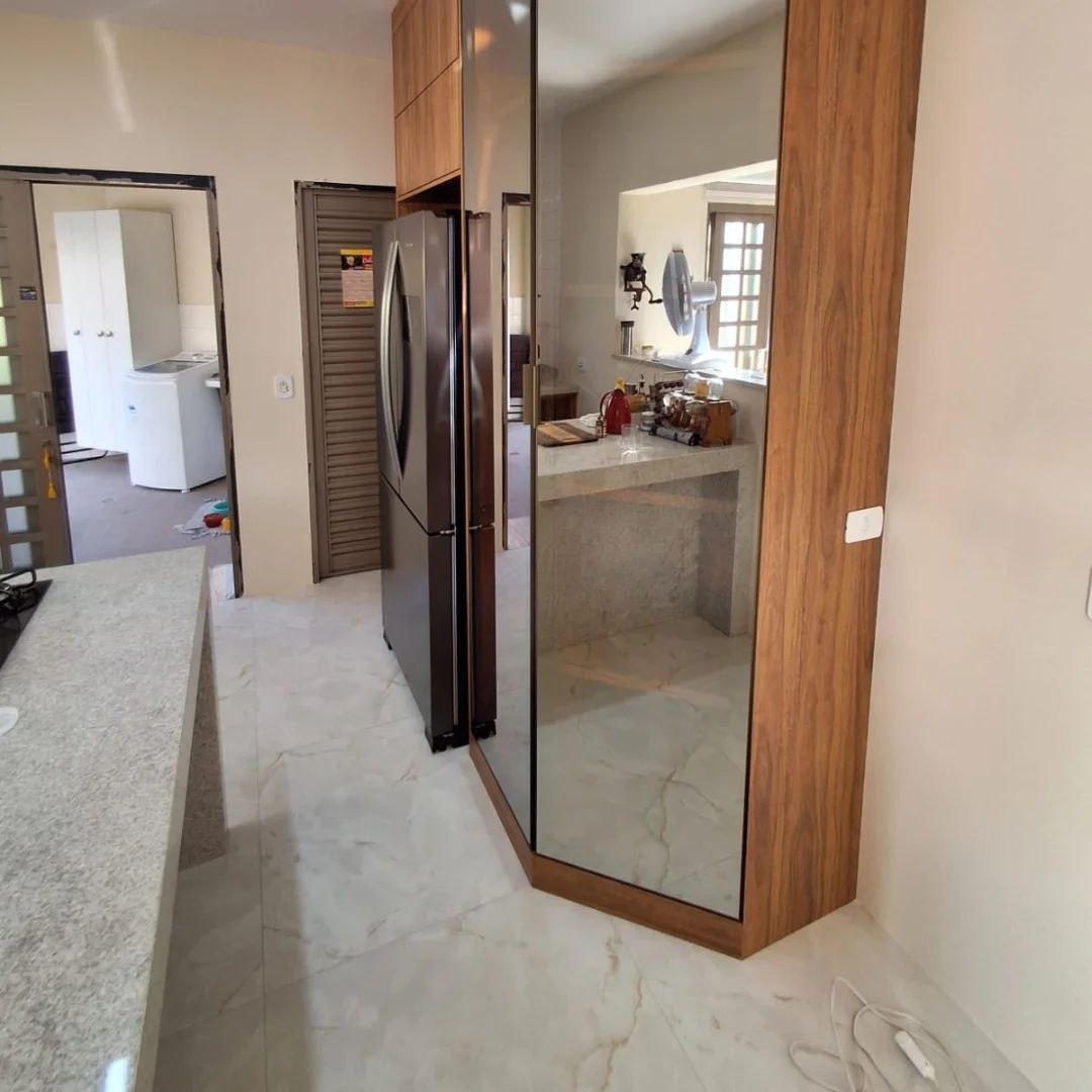 Armário planejado com porta espelhada integrando cozinha e área de serviço — Mollo Art
